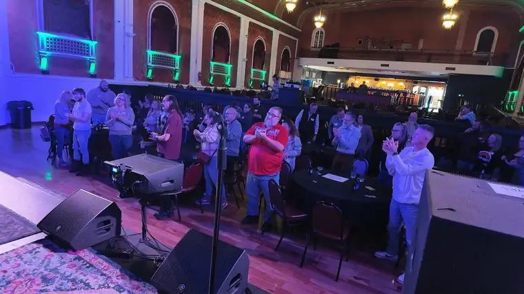 A full house on its feet in an ornate theater